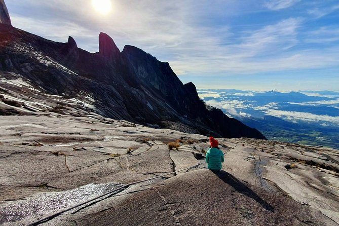 The jagged Donkey Ears peaks rising from Mount Kinabalu's granite plateau, with the Sabah lowlands under cloud beyond